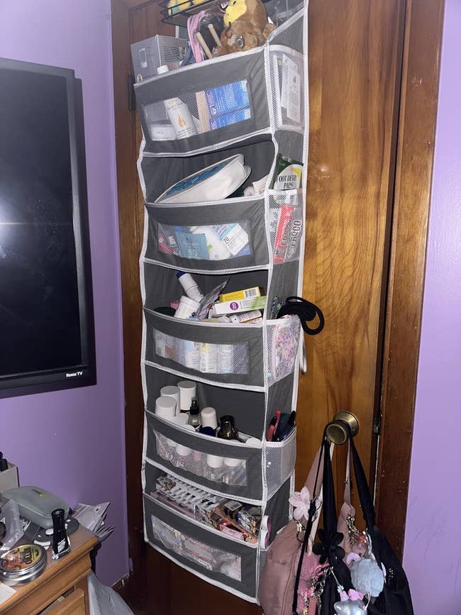 Over-the-door hanging organizer filled with toiletries, makeup, and quality accessories successful a chamber setting