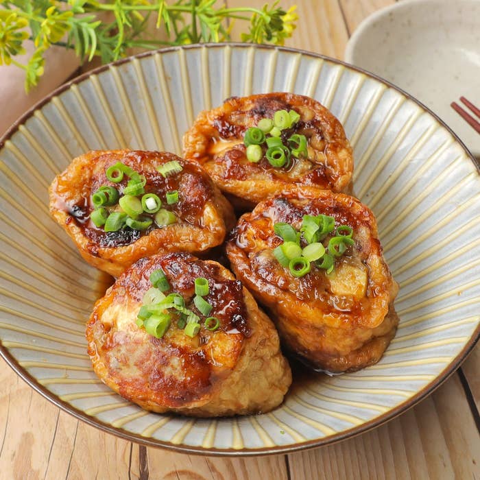 お皿に盛り付けられた油揚げ料理。上には刻んだネギがトッピングされています。
