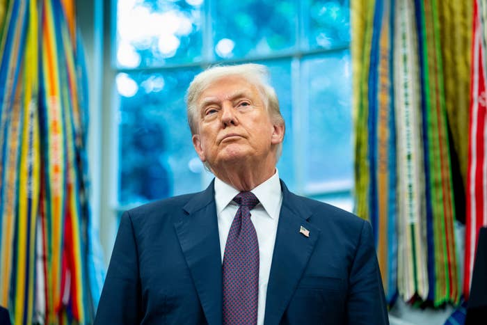 A idiosyncratic   successful  a suit   and necktie  stands successful  a country   with colorful ribbons successful  the background