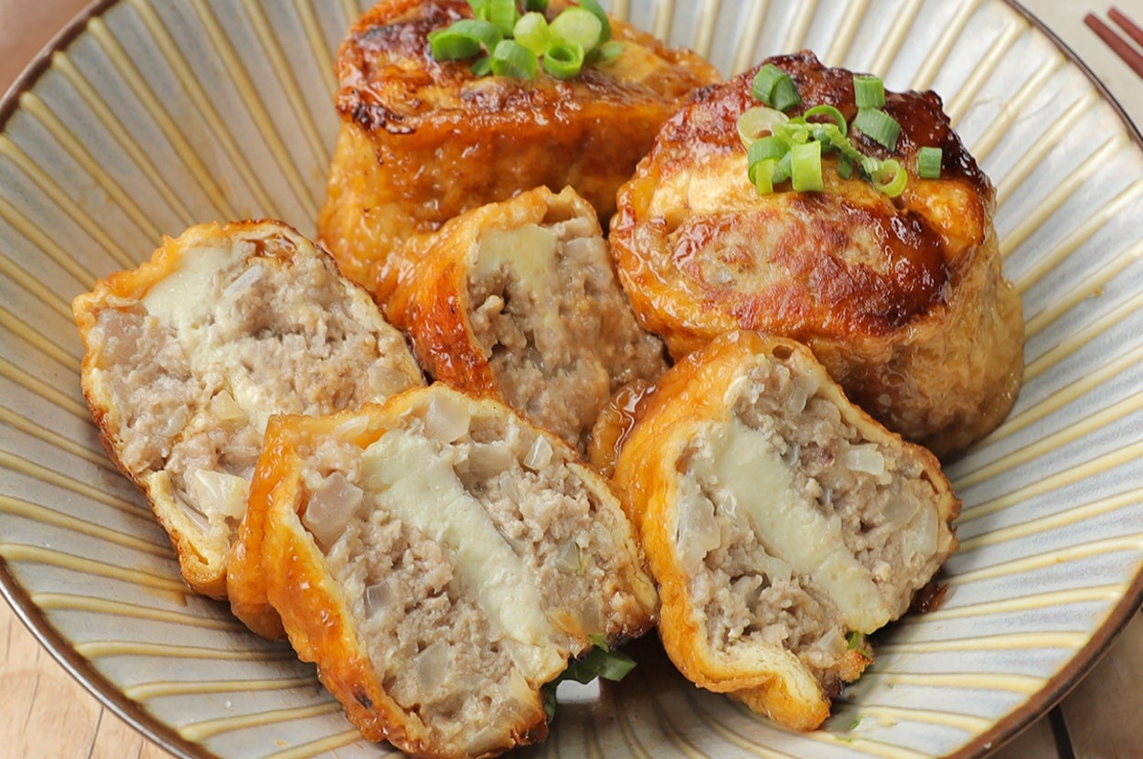 料理皿に入った肉詰め油揚げ。上に刻みネギが飾られている。