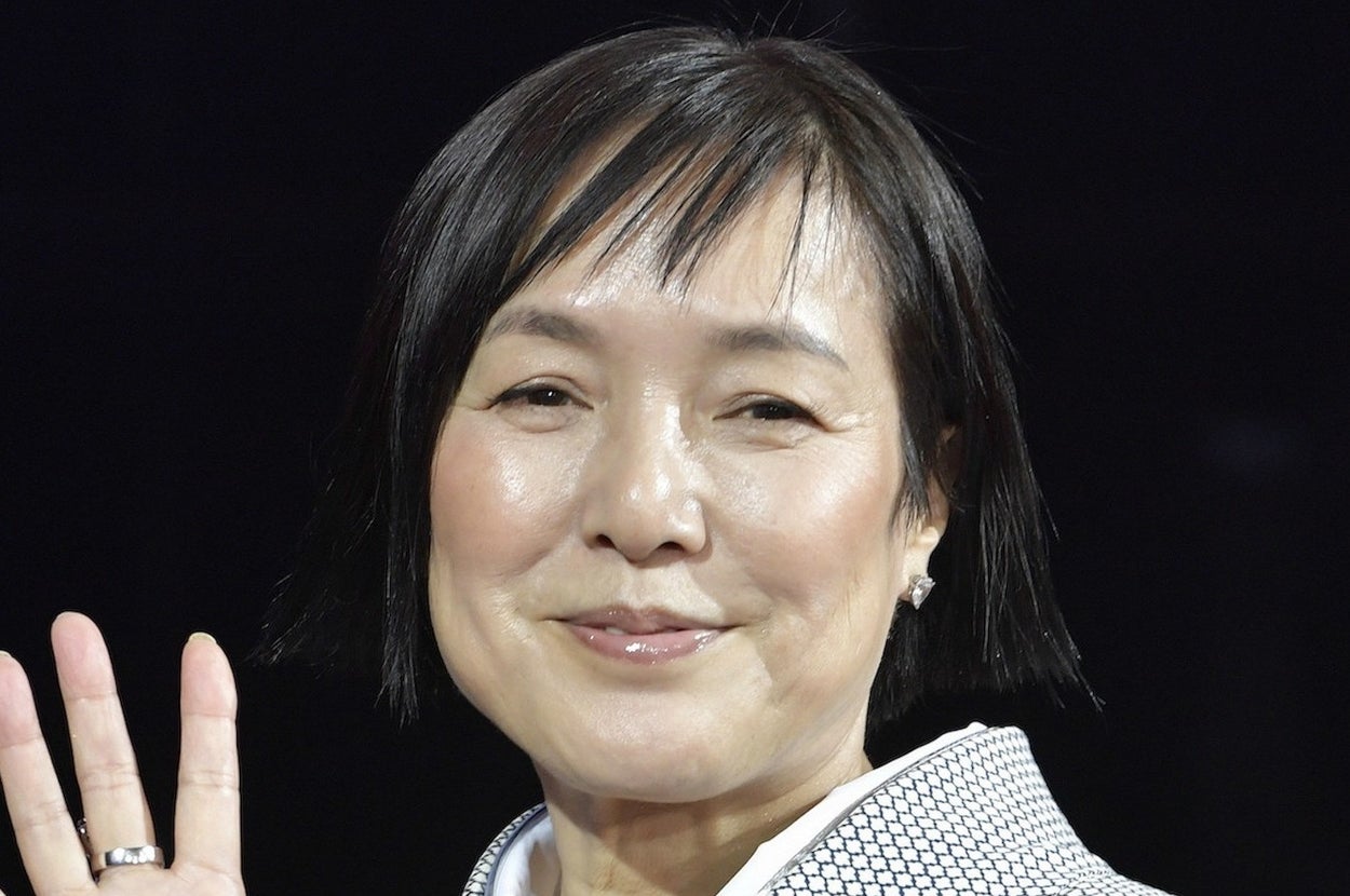 手を振る着物姿の女性。