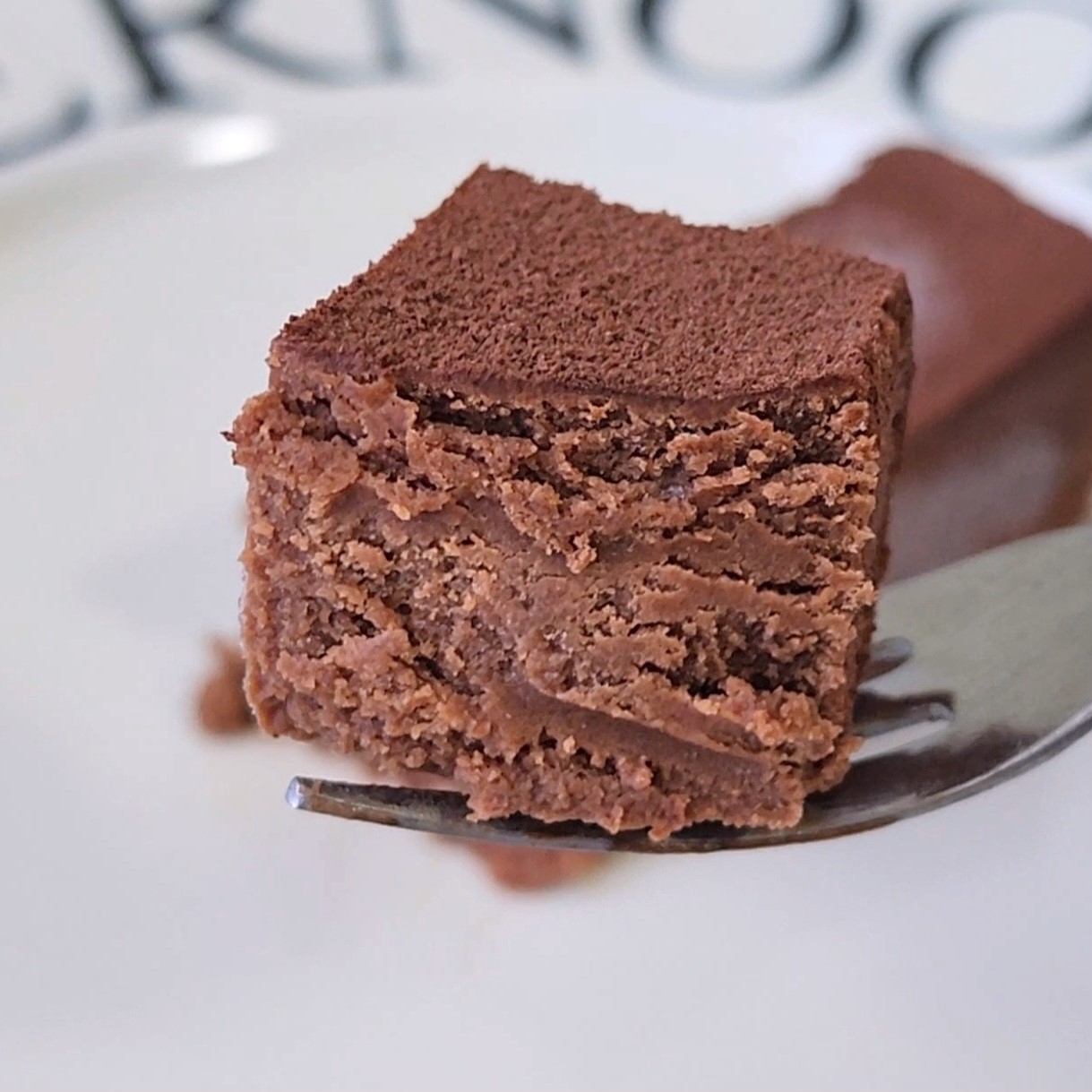 フォークにのったチョコレートガナッシュのケーキ。滑らかな層が見える。