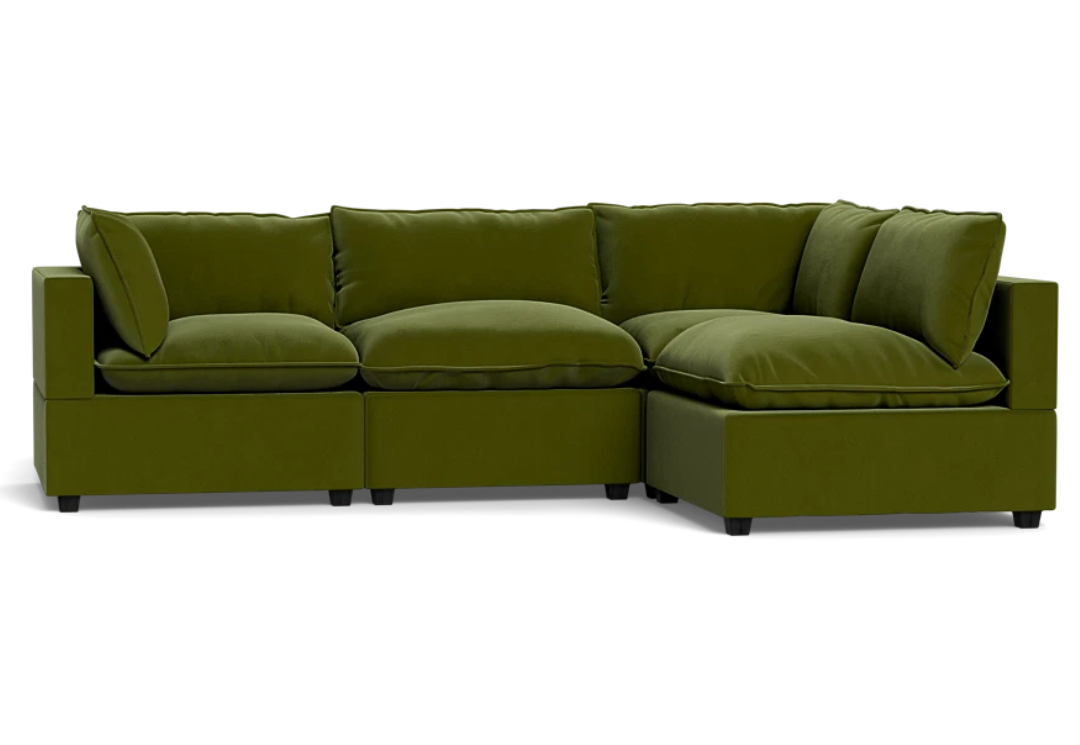 green velvet L-shaped sectional sofa with thick pillow cushions and a modern, boxy design