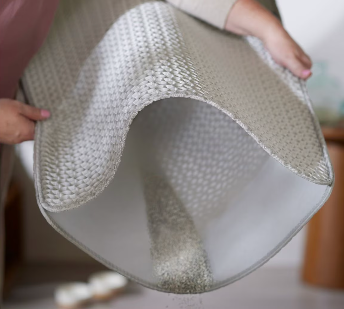Person shaking retired  an anti-slip rug implicit    a cleanable  floor, demonstrating casual  attraction    and attraction   for location  use
