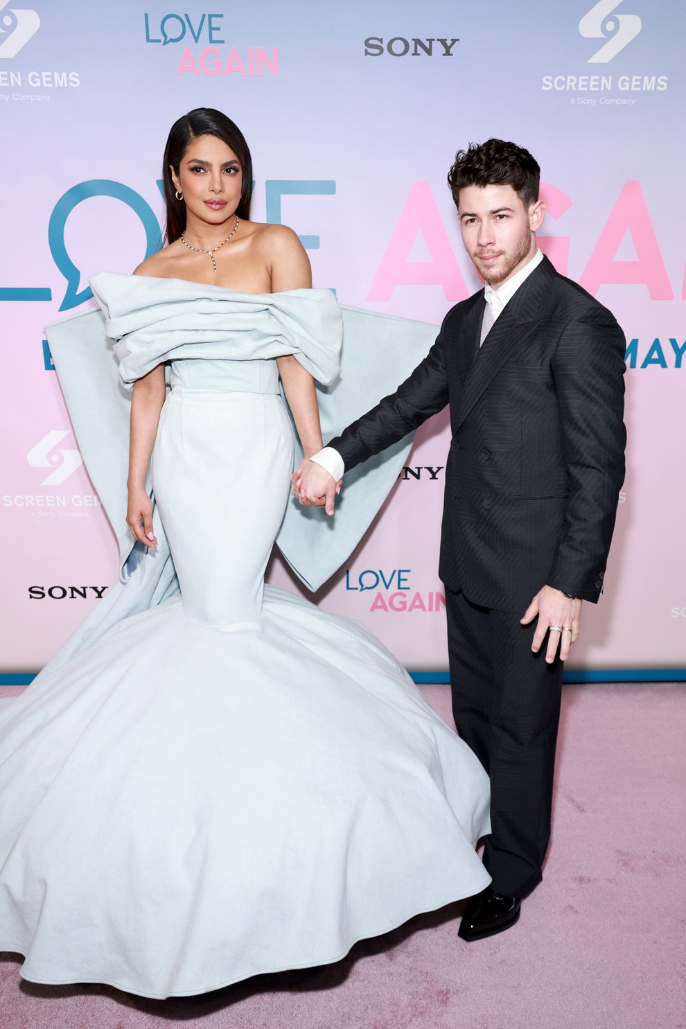24 Bizarre Celeb Facts That Sound Fake, But Are 100% True 22 A woman in an off-shoulder, gown poses with a man in a tailored suit at a "Love Again" event