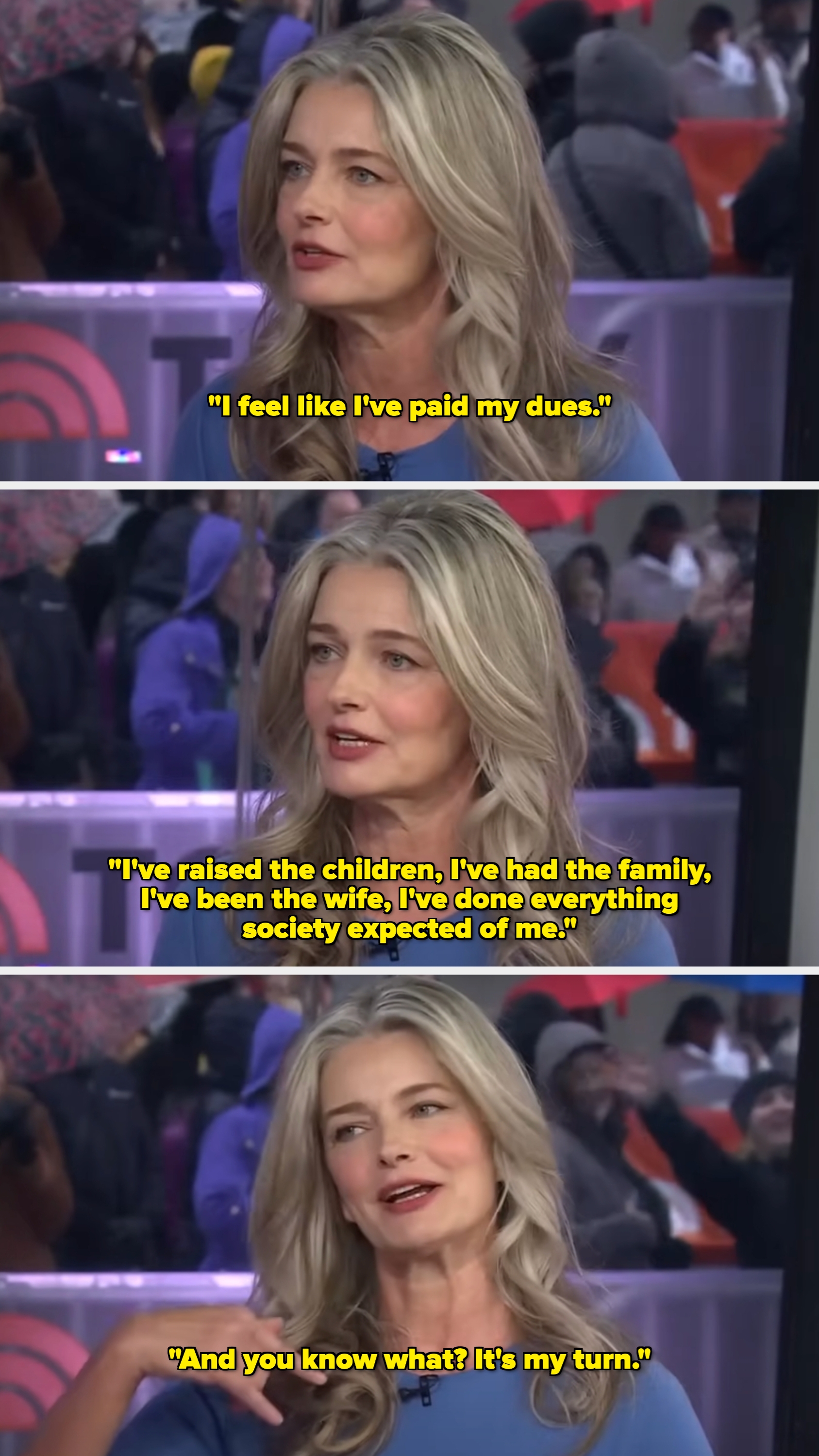 En kvinne med langt hår snakker animert under et TV -intervju, iført en enkel, elegant topp