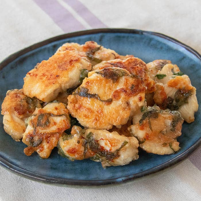 鶏むね肉を梅、大葉と一緒に焼いた料理が青い皿に盛られている。