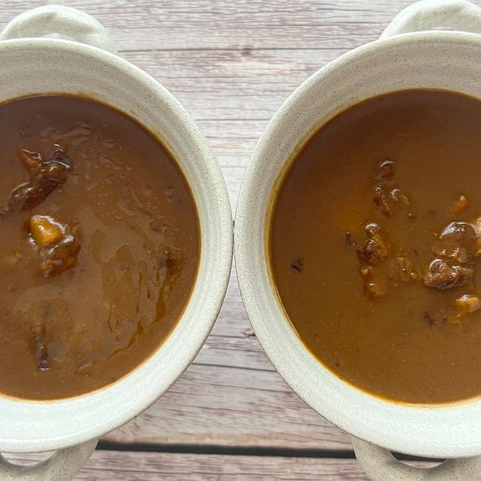 2つの白いボウルに盛られたカレー。具が少し見える。
