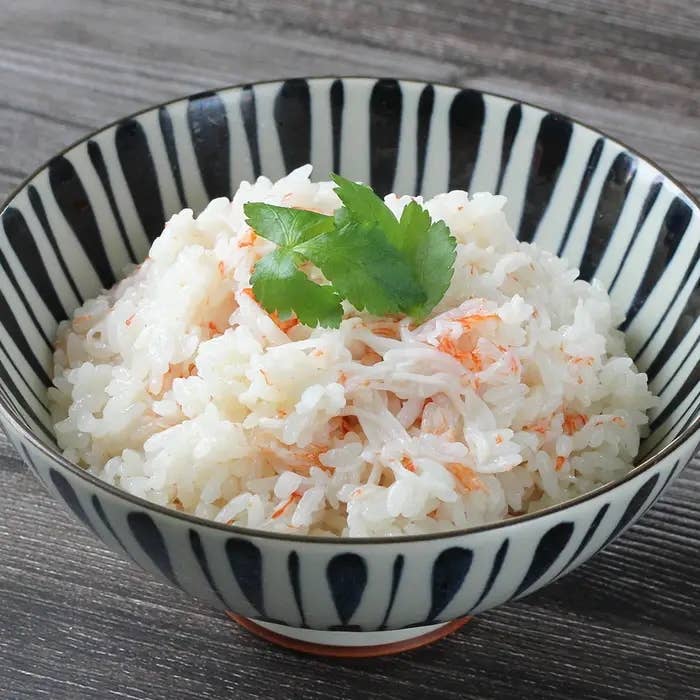 茶碗に盛られたご飯の上にミツバがのっています。