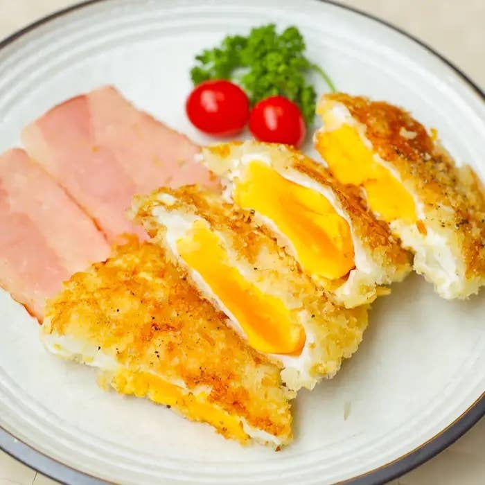 白い皿に、ベーコン、半熟卵フライ、プチトマト、パセリが盛り付けられている料理。