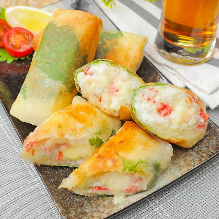 皿に盛られた揚げ春巻きと生春巻き。隣に飲み物があり、レモンやトマトが添えられている。