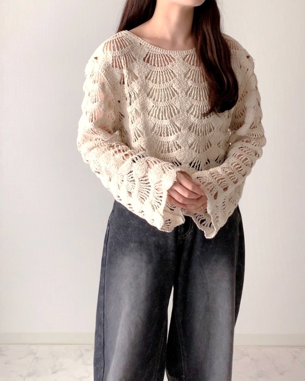 ルーズフィットのニットセーターとワイドパンツを着た人物が写っている。