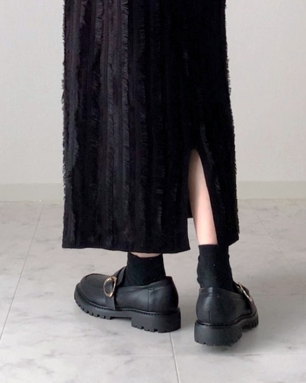 ロングスカートと黒の靴を履いた人の足元が映っています。