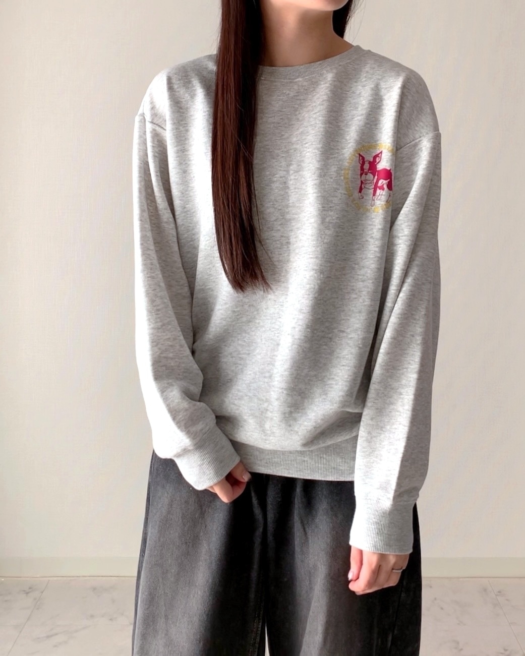 女性がカジュアルなスウェットシャツとゆったりしたパンツを着ている。