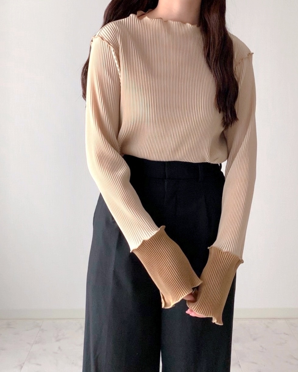 リブトップスとハイウエストパンツを着た人物。スタイリッシュな服装。