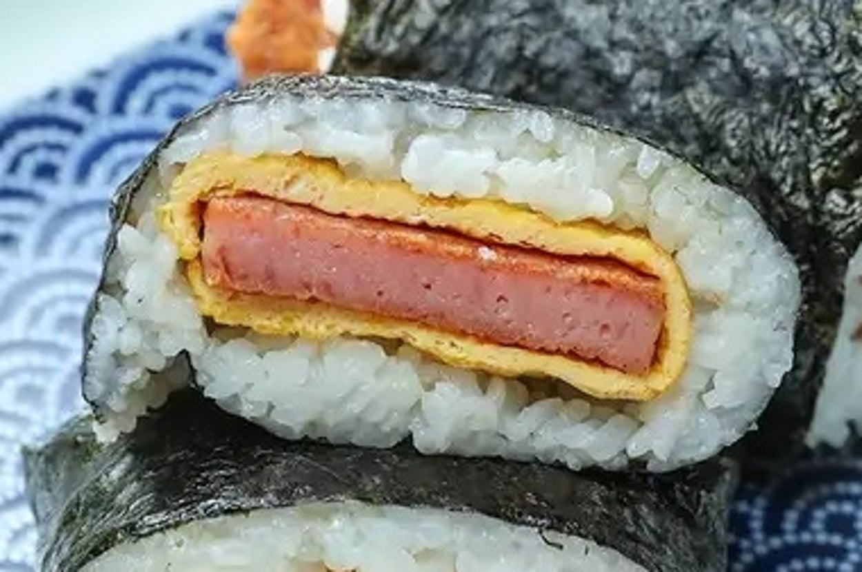 スパムむすびが皿にのっている様子。海苔で巻かれたご飯にスパムと卵が挟まれています。