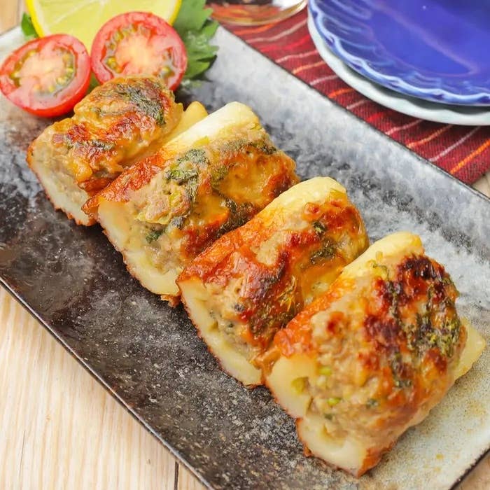 皿にのったチーズ焼きのちくわ、レモンとトマトが添えられている。