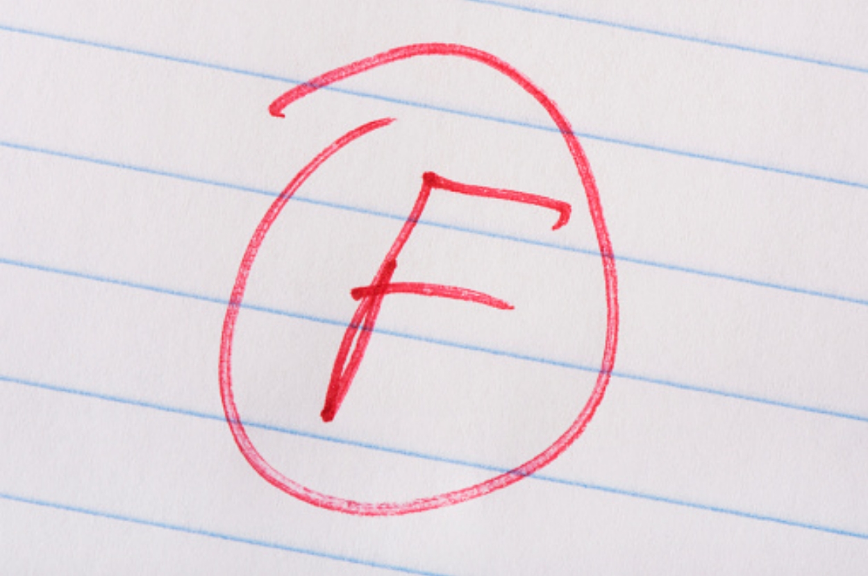 Red letter "F" circled on lined paper, indicating a failing grade