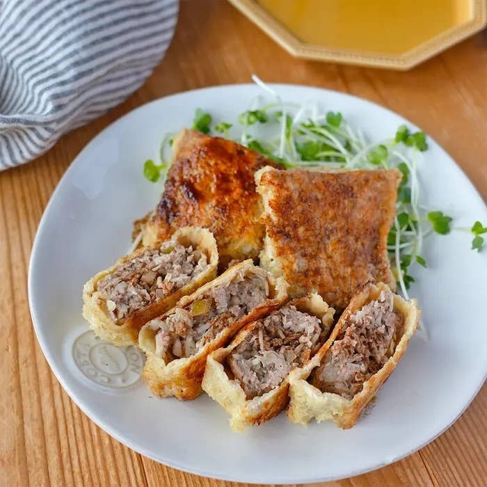 皿に盛られた具たっぷりの焼きギョーザの断面。食欲をそそるおいしそうな一品。