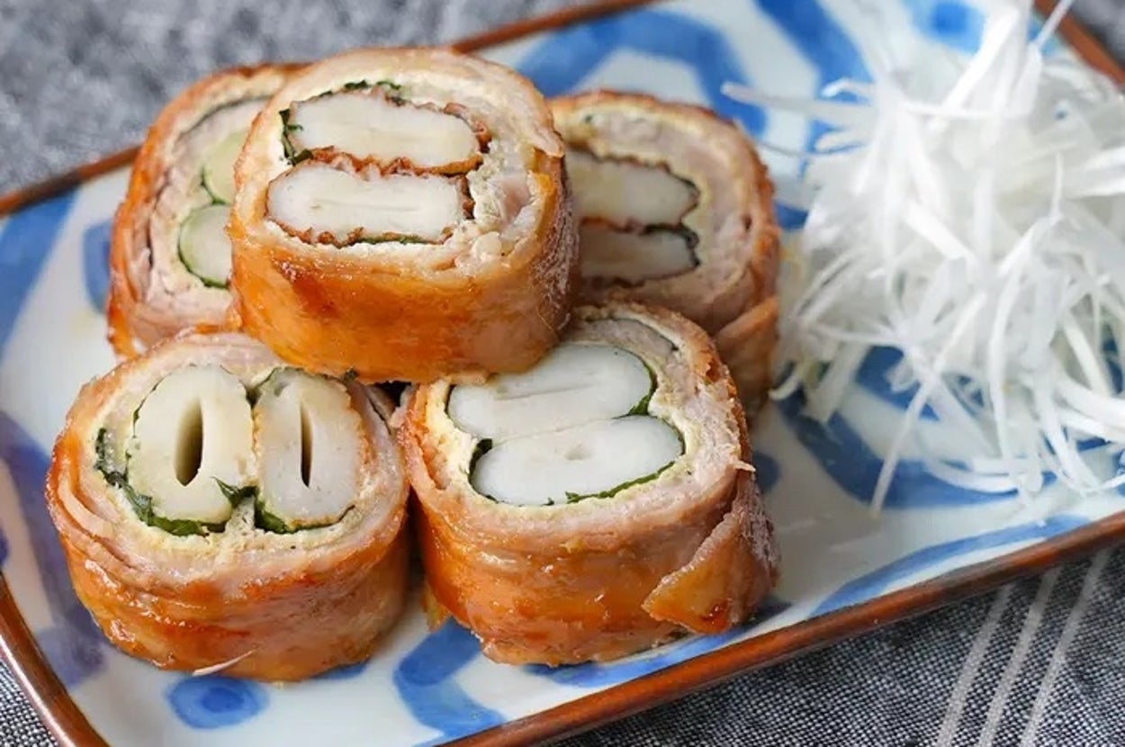 お皿に盛られた巻き寿司風の料理と千切りされた白い野菜の付け合わせ。