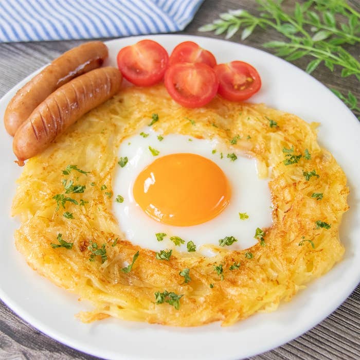 焼き上げたハッシュドポテト目玉焼き、ソーセージ、ミニトマトが皿に盛り付けられている。