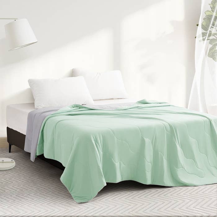 Modern chamber with neatly made bed, achromatic pillows, and airy comforter. Room has minimal decor with earthy airy streaming successful done a window