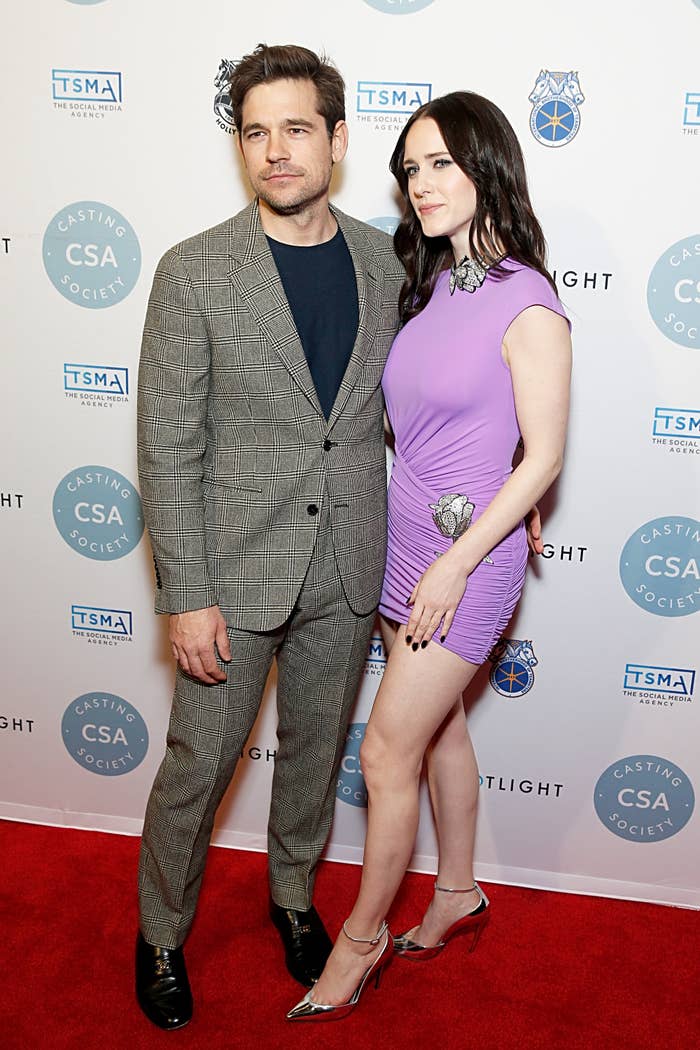 Jason Ralph in a checked suit and Rachel Brosnahan in a short dress with metallic accents