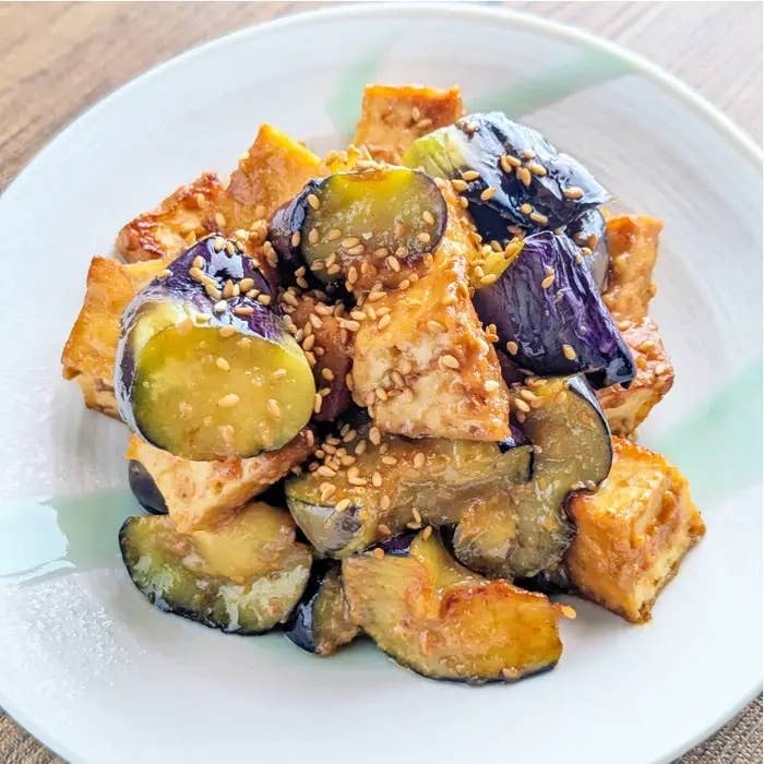 焼きなすと豆腐のごまソース和えが皿に盛られている。