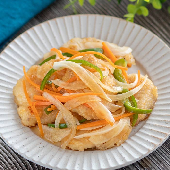 皿に盛られた揚げた魚の上に野菜の千切りが載った料理。