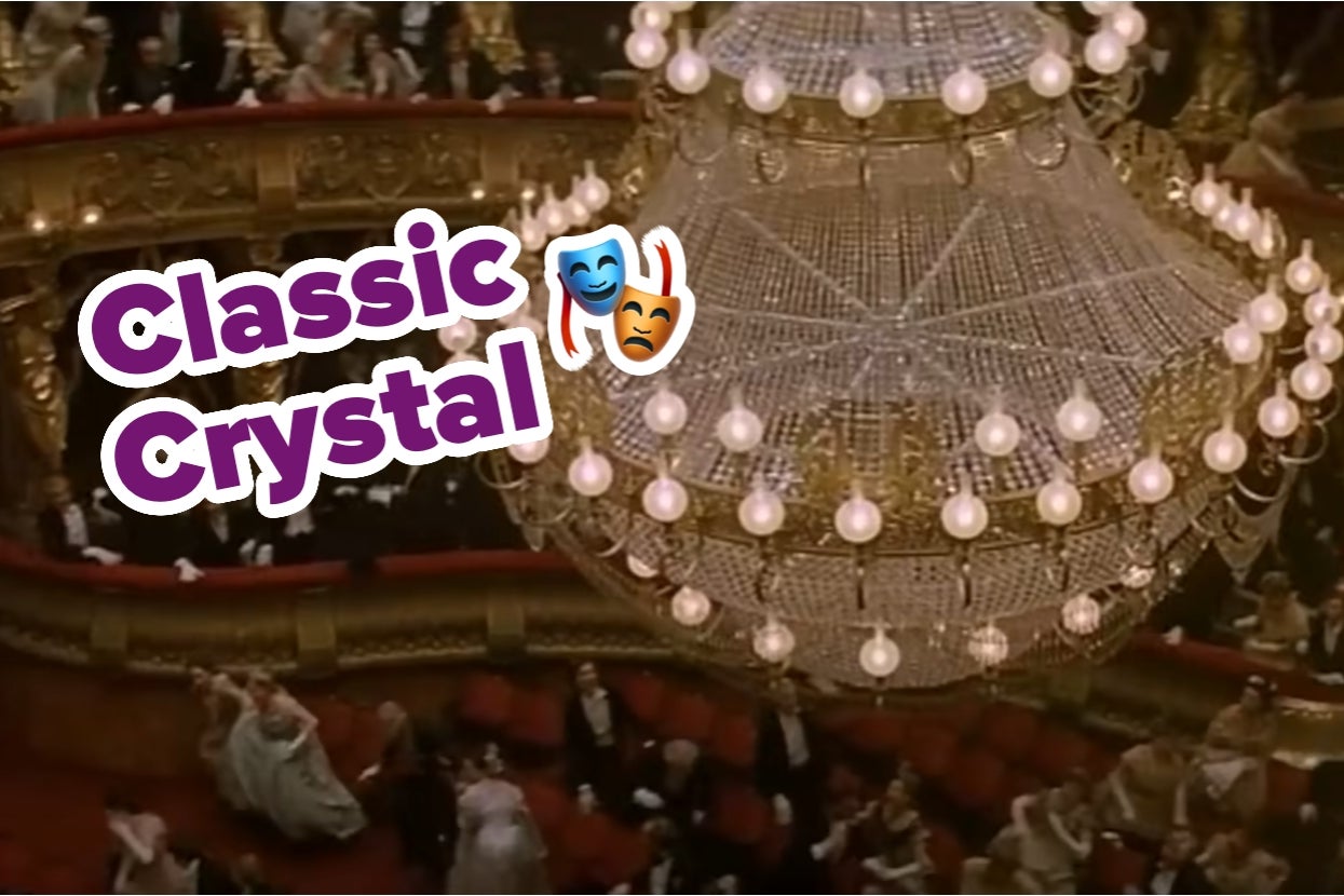 A grand chandelier hangs above an ornate theater in "The Phantom of the Opera," with "Classic Crystal" text and comedy-tragedy mask emojis overlaid