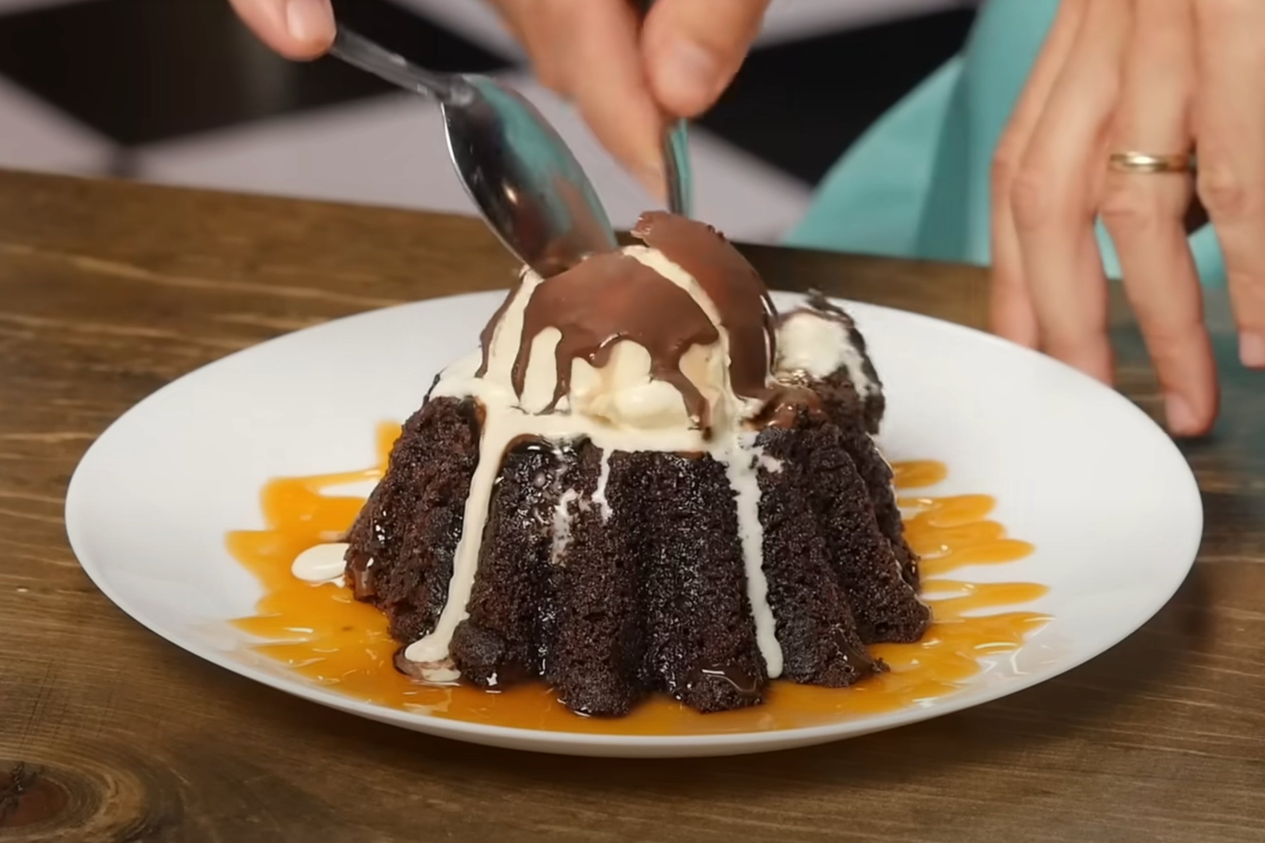 A person uses spoons to break the chocolate shell on a Chili's molten lava cake