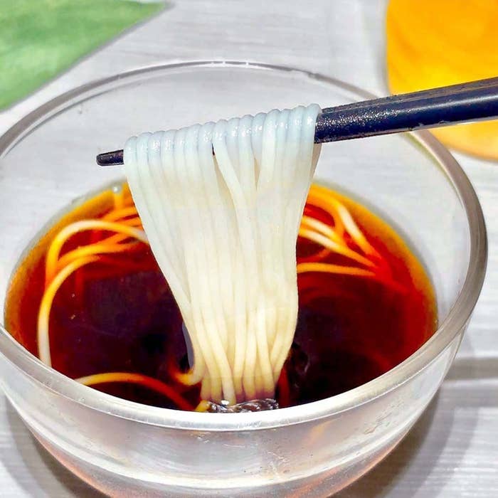 箸で持ち上げられているガラス器のそうめん。