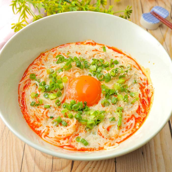 ラーメンの上に生卵とネギがのっている料理。