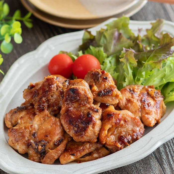 皿に盛り付けられた焼き鳥の料理。付け合わせにレタスとトマトが添えられている。