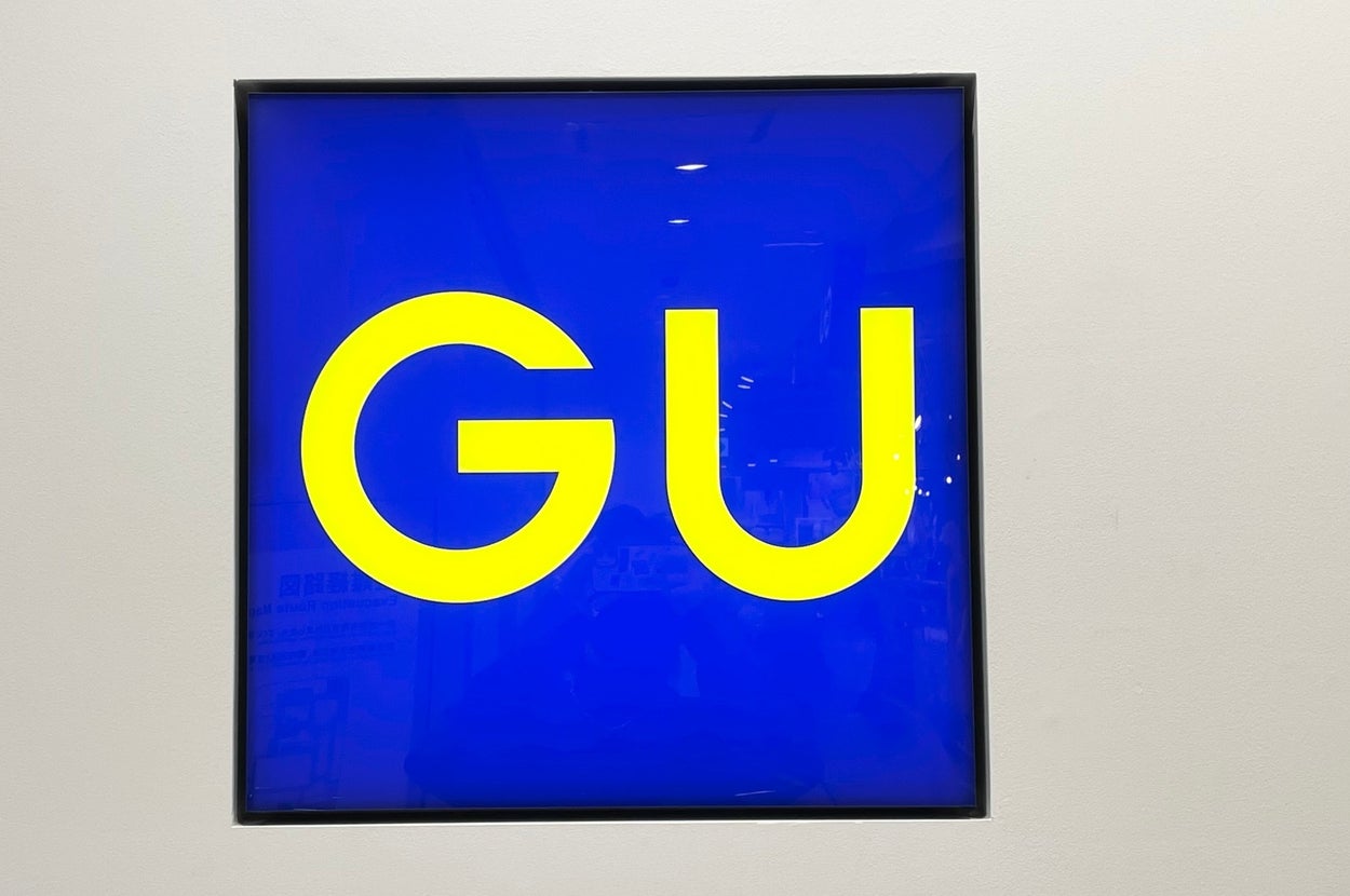GU brand logo displayed on a store wall