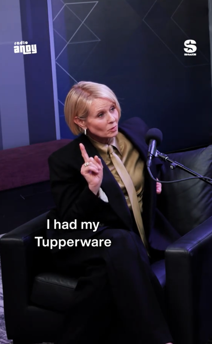 Person in a suit speaks into a microphone, holding up one finger. Text overlay reads "I had my Tupperware."
