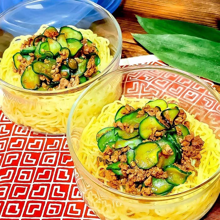 ガラスの器に入った麺の上に、きゅうりと細かい肉がトッピングされています。