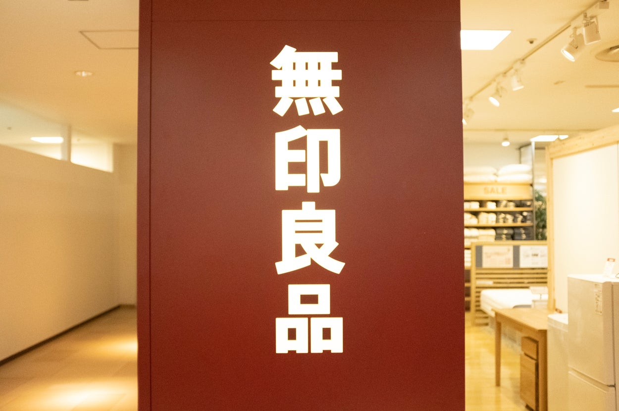 Japanese characters on a wall inside a store, next to shelves with home goods