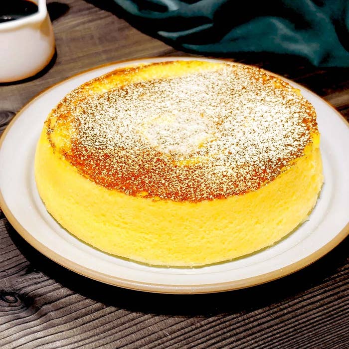 ふわふわのケーキが皿に盛られ、上に粉砂糖がかけられている。