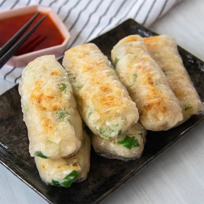 皿に並んだライスペーパー料理が黒いプレートにのっている。隣にしょうゆの小皿が置かれている。