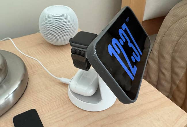 Smartphone and smartwatch charging connected a woody nightstand, utilizing a dual charging dock with a integer timepiece display