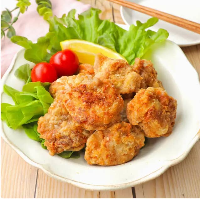 皿に盛られた唐揚げ、レモンスライス、リーフレタス、ミニトマトが添えられた美味しそうな料理。