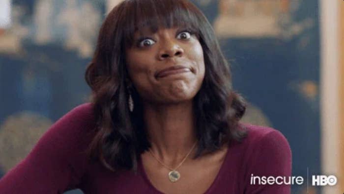 Actor from the amusement "Insecure" looks surprised, rima somewhat open. She wears a necklace and a long-sleeved top