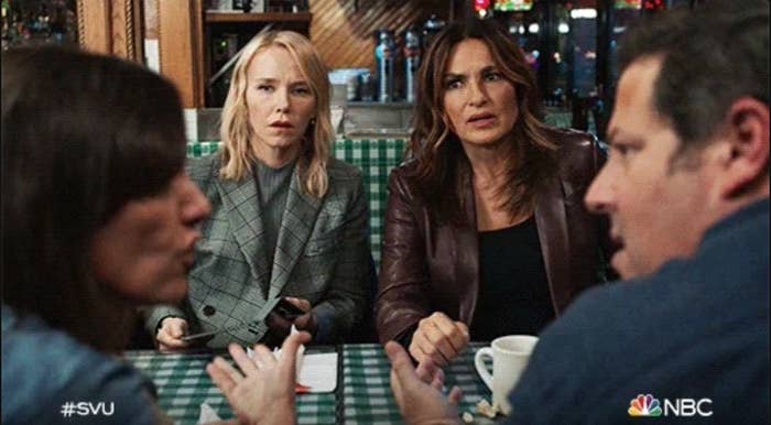 Two women successful a diner, focused connected a speech with 2 seated people, with 1 holding a notepad. Scene related to "SVU" connected NBC