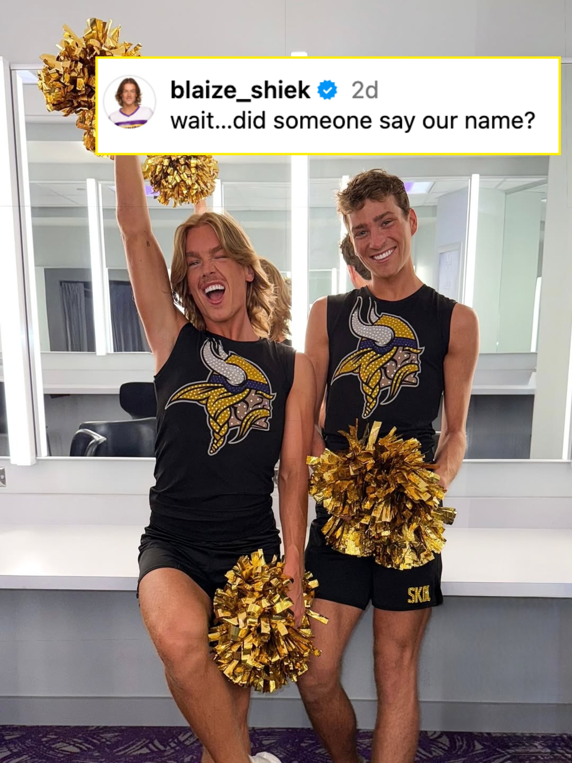 Two individuals in matching Vikings cheer outfits hold pom-poms, smiling excitedly. They appear to be in a backstage area