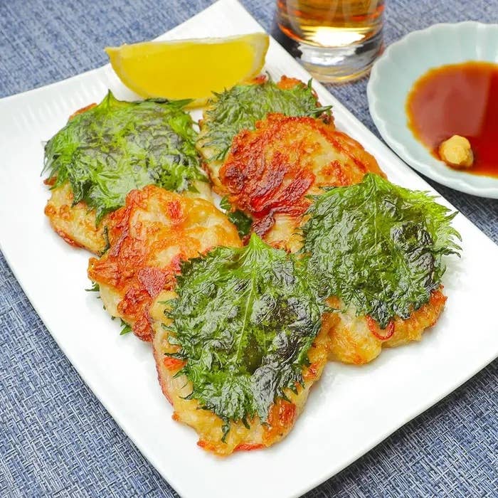 大葉のせた鶏肉の揚げ物が皿に盛られている。レモンとしょうゆ皿も添えられている。