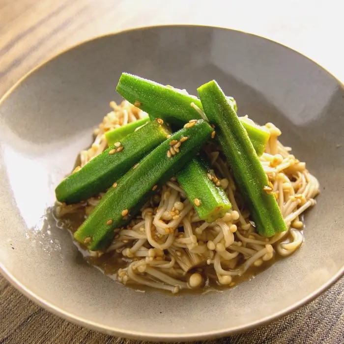 皿に盛られたエノキとオクラの和風料理。ゴマがトッピングされている。