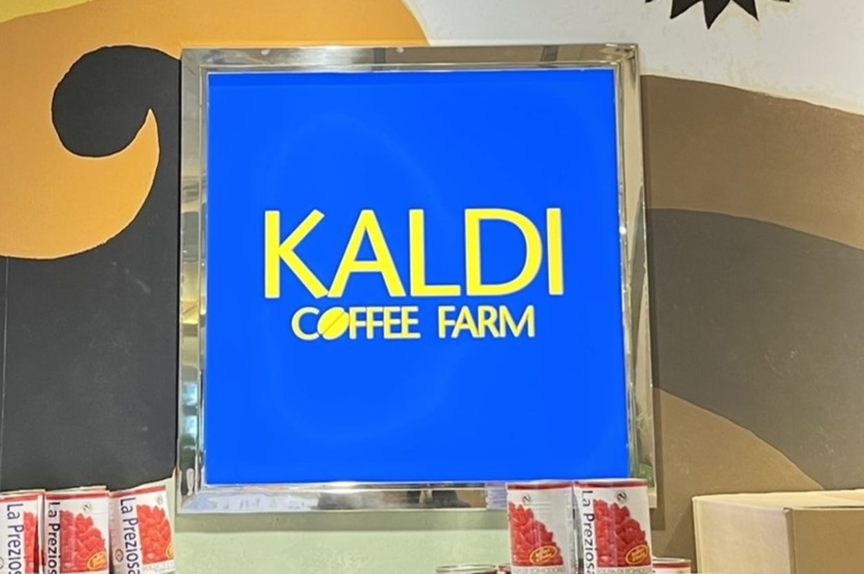 カフェチェーン「カルディコーヒーファーム」の看板。背景にデザインされたウォールアートが見える。