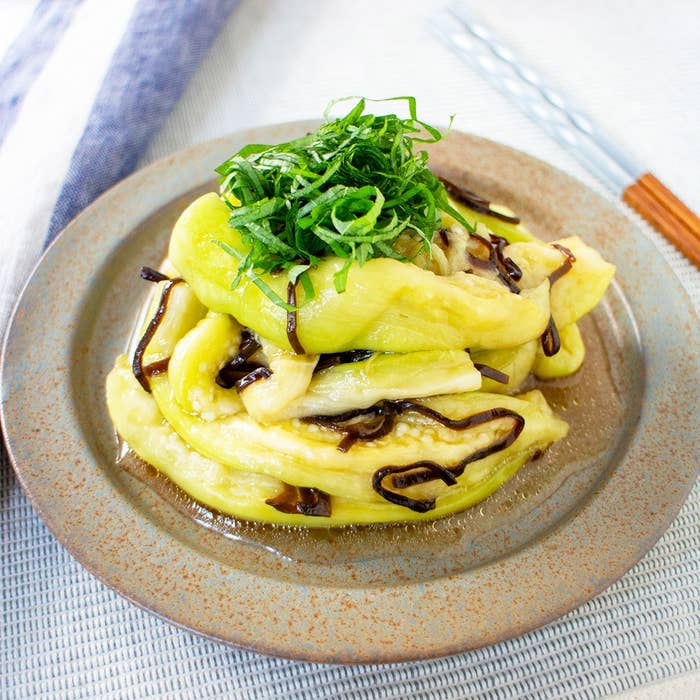 お皿に盛り付けられたナスの料理。上には刻まれたシソがのっています。和風の味付けが感じられます。