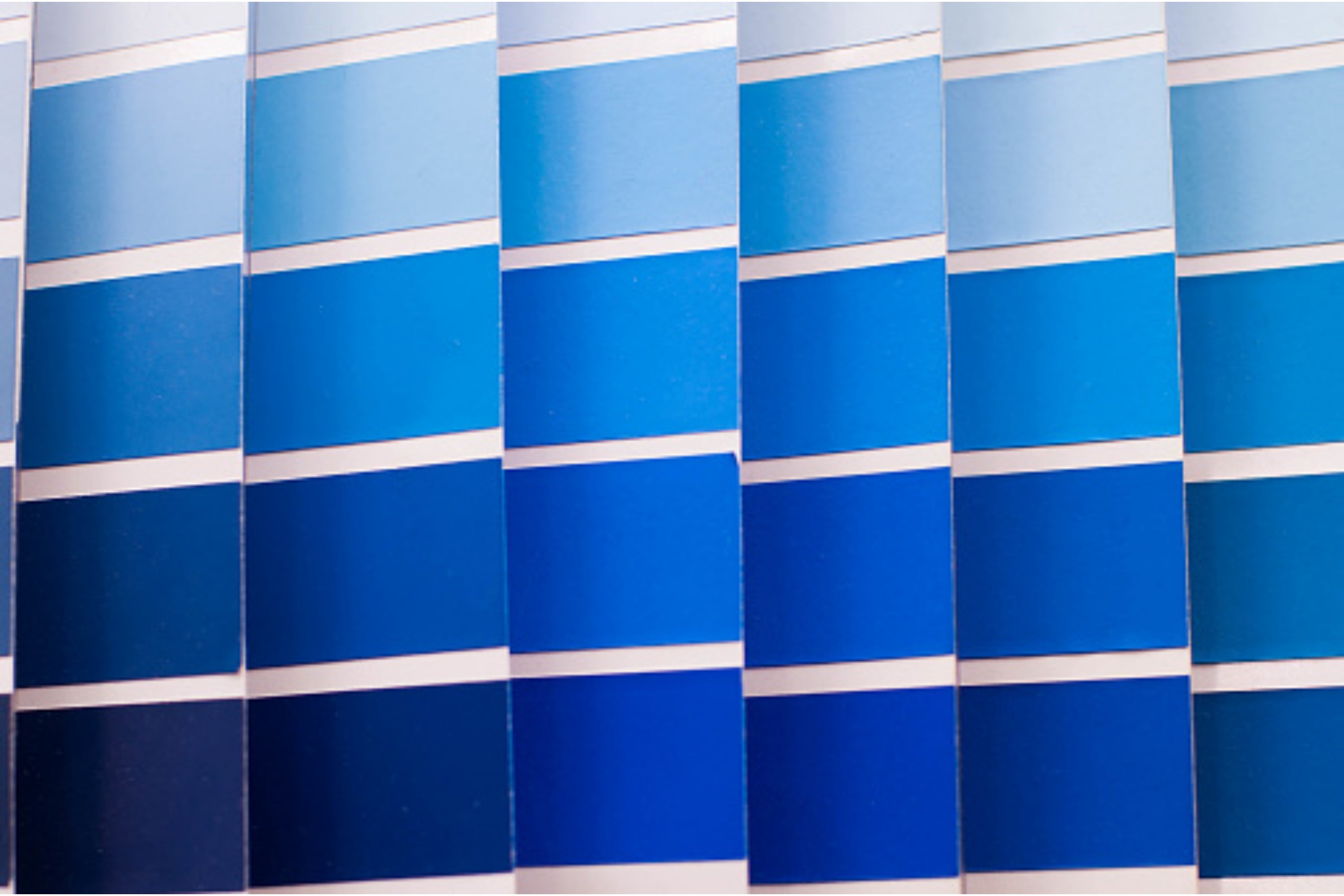 Stacks of colorful paper arranged in a curved pattern, showcasing a variety of hues
